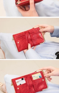 Detail of red vintage wallet featuring gold clasp, multiple card slots and zipper pocket