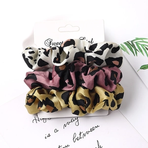 Three-piece set of leopard print satin hair scrunchies on white display card