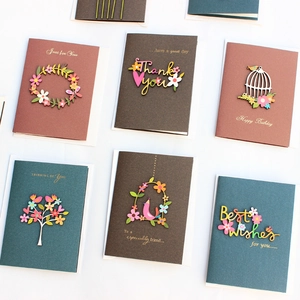 Assorted handmade greeting cards with 3D wooden ornaments on brown and green paper