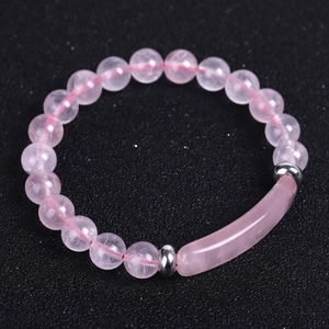 Natural pink crystal stone beaded bracelet with stainless steel accents on black background