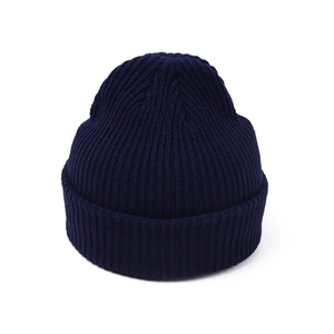 Detailed close-up of dark blue ribbed knit beanie with high-quality vertical texture