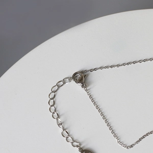 Detailed close-up of the lobster clasp and adjustable extension chain on silver necklace