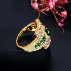 Macro shot of gold ring with emerald-cut green gemstone and pave zircon crystals