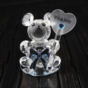 Detailed macro view of a crystal teddy bear figurine featuring a blue bow and a heart sign