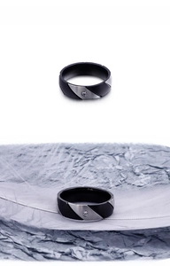 Detail of two-tone stainless steel ring with diagonal split texture and center zircon