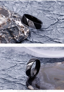 Macro detail of two-tone black and silver brushed steel ring with a small center stone