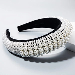Detailed side view of luxury headband with layered pearls on black fabric base