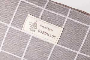 Detail of grey checkered cotton linen fabric texture and handmade natural style label
