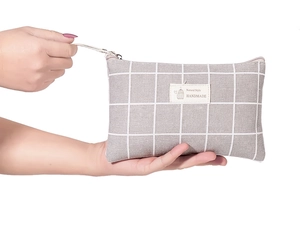 Close-up of grey plaid canvas cosmetic bag with Natural Style handmade label detail