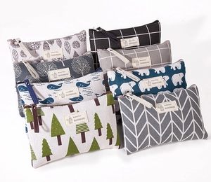 Macro shot of assorted canvas cosmetic bags featuring leaves, polar bears, and plaid patterns