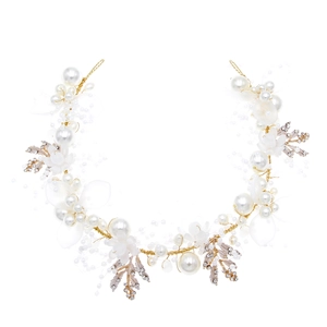 Detailed macro view of bridal hairband with pearls, beads and golden leaf metal accents