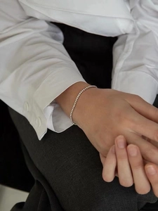 Close-up of minimalist silver tennis bracelet with cubic zirconia worn by a model