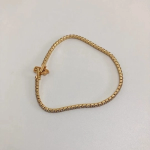 Detail of gold tennis bracelet with clear zircon stones in square prong setting