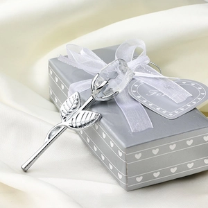 Detailed macro of crystal rose petals with silver metallic stem resting on a gift box
