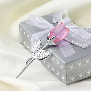 Detail of pink crystal rose with silver stem resting on a heart-patterned gift box