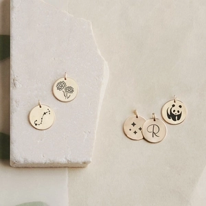 Detailed view of 9mm gold-plated stainless steel charms with animal and star engravings