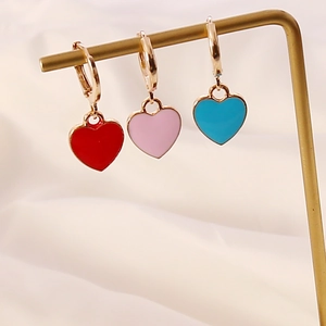 Detailed macro view of colorful drip oil heart earrings in red, pink and blue shades