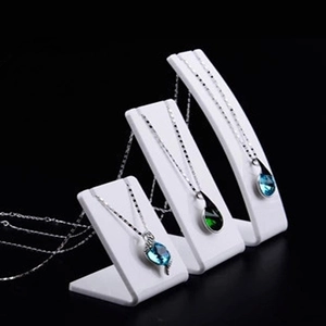 Three-tier white acrylic jewelry display stands for necklaces on a black background