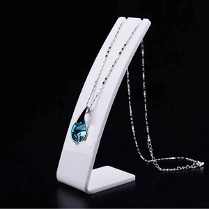 Blue teardrop crystal necklace on a white L-shaped acrylic jewelry display stand