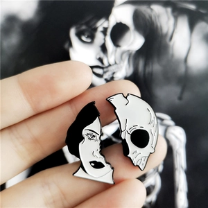 Détail de broches en émail à visage divisé montrant un visage de femme et un crâne demi