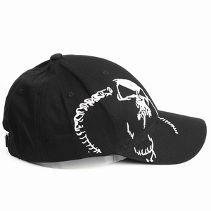 Close-up of white skull bone embroidery on the side of a black cotton baseball cap
