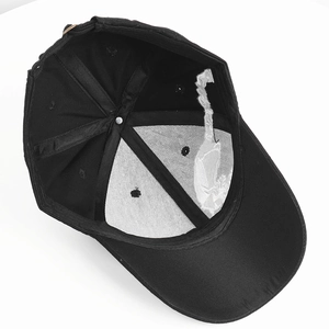 Detail of black baseball cap interior with 6-panel structure and brass buckle strap