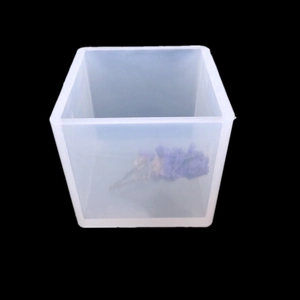 Close-up of translucent square silicone mold for resin with dried purple flower inside