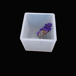 Close-up of translucent square silicone resin mold with dried purple flowers inside