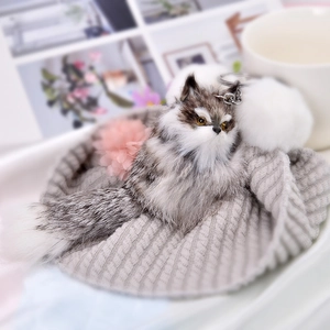Plush fox keychain with faux fur ball and metal clasp in a cozy knitted hat setting