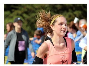 Action shot of pink running vest with run alex print and black arm sleeves