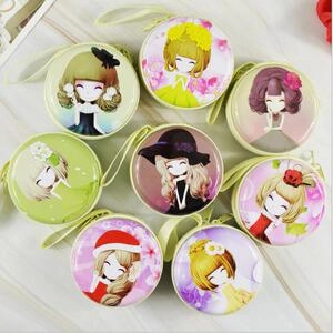 Close-up of circular tinplate coin purses with cartoon girl prints and wrist straps