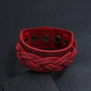 Close-up of red woven leather bracelet with vintage texture and metal snap buttons