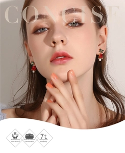 Close-up of bowknot bell earrings with red glitter, green rhinestones and pearl pendant