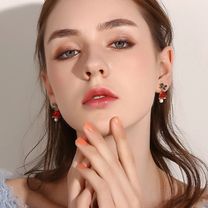 Christmas red bell earrings with green glitter and white pearl dangles on model