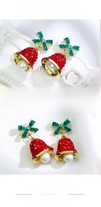 Detail of Christmas bell earrings with red and green rhinestones and a white pearl drop