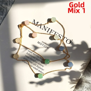 Close-up of golden necklace with colorful pastel square beads on a stylish magazine