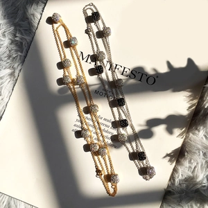 Detailed view of gold and silver sweater necklaces with square zircon pendants