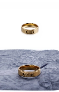 Detail of gold stainless steel ring with DAD engraving and brushed texture surface