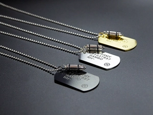 Detailed view of U.S. Army bullet pendants in gold, silver and black brushed steel