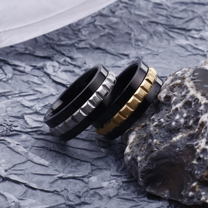 Men's titanium steel gear ring with black matte finish on a natural rock background