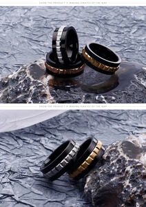 Close-up of industrial gear patterned steel rings for men in black and gold finishes
