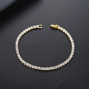 Elegant gold-plated tennis bracelet with square-cut zircons on a dark textured surface