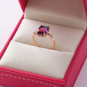 Macro detail of rose gold ring with bicolor rectangular crystal in a velvet jewelry box