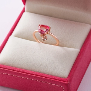 Macro shot of rose gold heart ring with pink gradient stone in a jewelry gift box