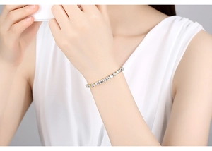 Close-up of a gold-plated tennis bracelet with clear zircon stones on a female wrist
