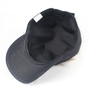 Detailed view of black baseball cap interior showing 100% cotton label and faux hair