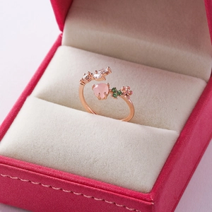 Macro view of adjustable rose gold ring with heart-shaped pink gem and leaf details