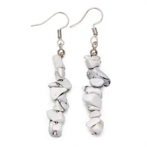 Close-up of dangling stone earrings with white marble texture and silver hooks