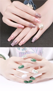 Close-up of geometric pink and grey nails with gold studs, pearls and plaid patterns