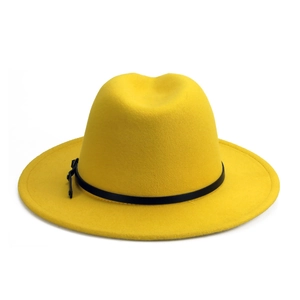 Detail of a bright yellow fedora hat featuring a stylish black leather buckle belt accent